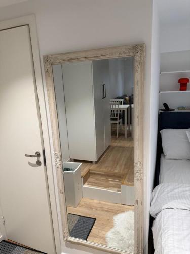 ein Spiegel in einem Zimmer mit einem Bett und einem Schlafzimmer in der Unterkunft Between The Trees 2 in Agnesberg