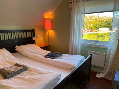 two beds in a room with a window at Hedvig Guesthouse & Ragnahus in Bugøynes