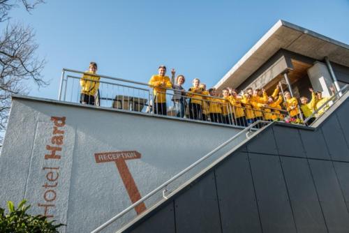 a group of people in yellow jackets standing on a building at Junges Hotel Hard am Bodensee in Hard