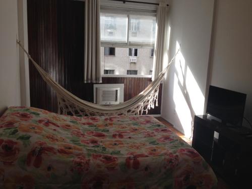 1 dormitorio con hamaca frente a una ventana en Apartamento Nossa Senhora, en Río de Janeiro