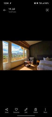 a room with two beds and a large window at Hotel Royal EdelWeiss in Leh