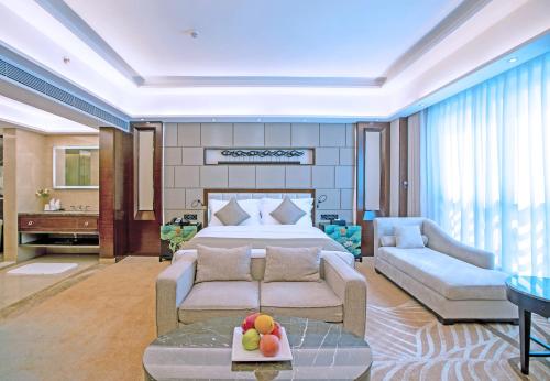 a large bedroom with a bed and a couch at Maoming International Hotel in Maoming