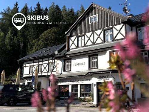 a large white building with flowers in front of it at Hotel Lomnice in Špindlerův Mlýn