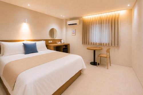 a hotel room with a bed and a desk at 부산 수영 블루닷 호텔 in Busan