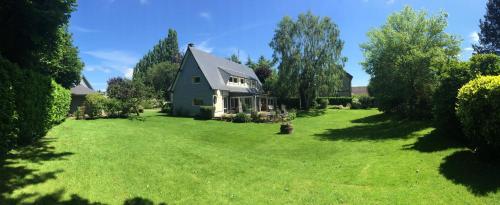 a house in a yard with a green lawn at Chambre D'Hôtes le Phenix in Saint-Martin-du-Vivier