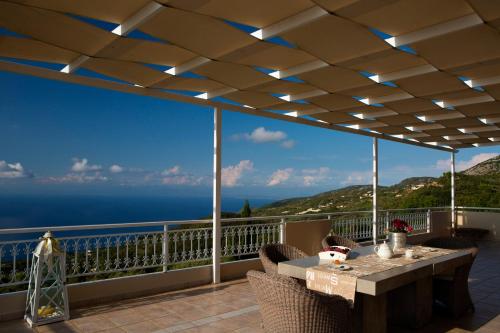 a patio with a table and chairs and the ocean at Amalia Apartments in Exanthia