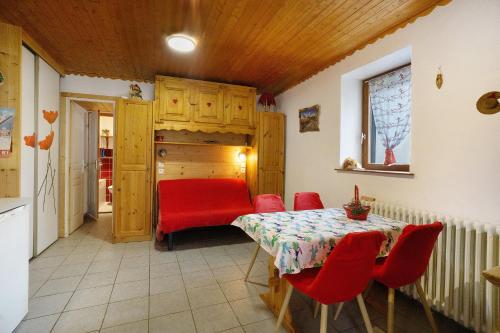 a dining room with a table and red chairs at Studio cabine - Les ecrins 2 in Valloire