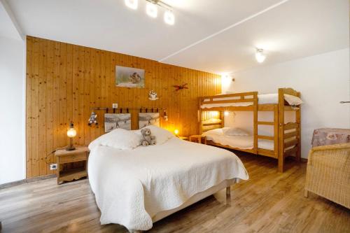 a bedroom with two bunk beds and wooden walls at Appartement - Les ecrins 3 in Valloire