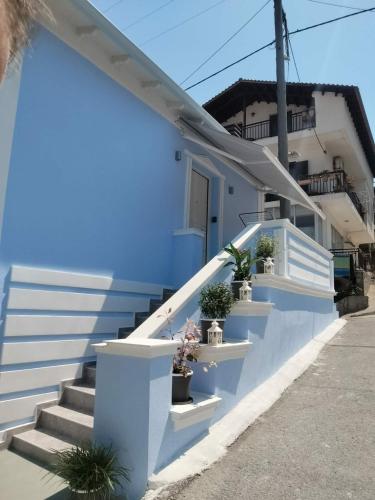 a blue building with stairs and potted plants at Mpampis House in Ammouliani