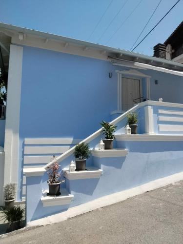 a blue house with potted plants on the side of it at Mpampis House in Ammouliani