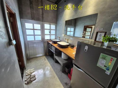 a kitchen with a counter with a sink and a refrigerator at 未半文旅 in Yilan City