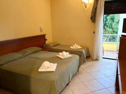 two beds in a room with towels on them at Hotel Costa Doro - Salve in Salve