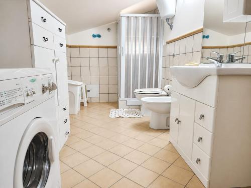 a bathroom with a washing machine and a sink at MANSARDA COSTA BIANCA - Free Parking in Realmonte