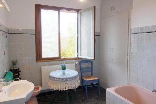 a bathroom with a table and a sink and a tub at Charmante maison Corisande in Gerde