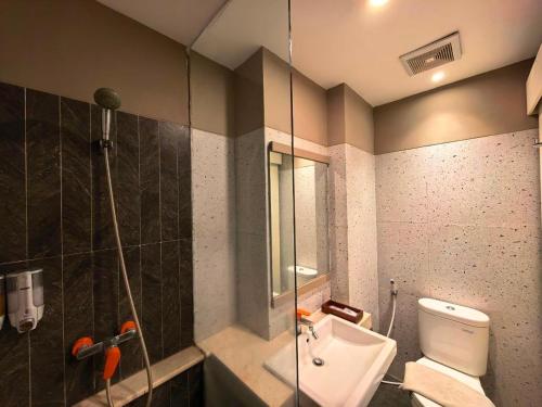 a bathroom with a toilet and a glass shower at Marra Hotel in Yogyakarta