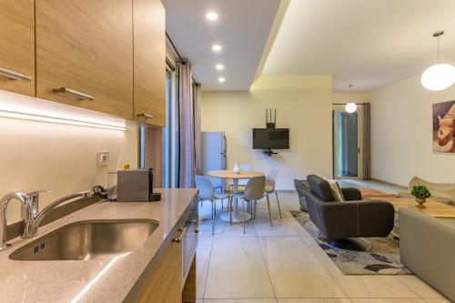 eine Küche mit Spüle und ein Wohnzimmer in der Unterkunft Papiro Apart Hotel in Byblos