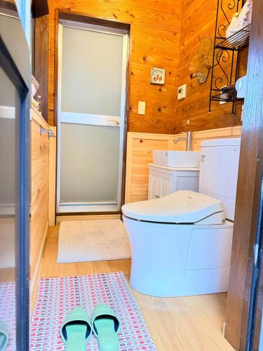 a bathroom with a toilet and a pair of shoes at Foresta Karuizawa 7 Glamping & camping for 8 people in Naganohara