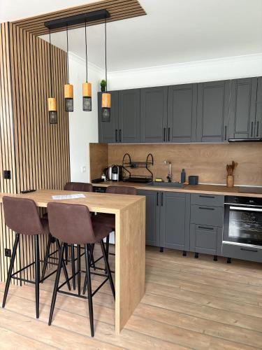 a kitchen with black cabinets and a wooden table at Pine Forest Apartments in Pamporovo