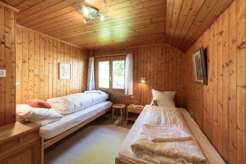 a bedroom with two beds in a wooden cabin at Central in Wildhaus