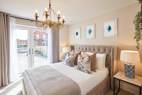 a bedroom with a bed with a window and a chandelier at The Hampton Garden in Whitby