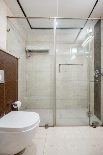 a bathroom with a shower with a toilet and a tub at Royal Residence 90 in Gumgaon
