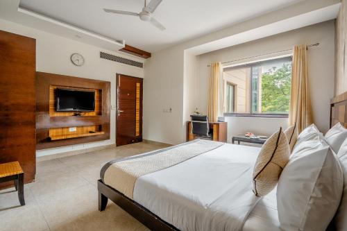 a bedroom with a large bed and a tv at Royal Residence 90 in Gumgaon