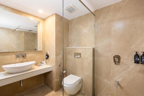 a bathroom with a toilet and a sink and a shower at juSTa Riverside Resort Srinagar in Devaprayāg