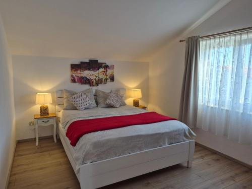 a bedroom with a bed with two lamps and a window at Boutique Apartments Julija in Vodice