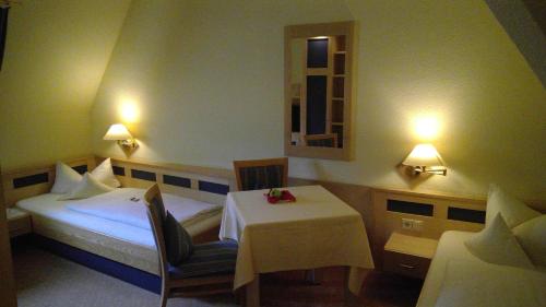 a hotel room with a bed and a table with a white table cloth at Hotel Augsburger Hof in Augsburg