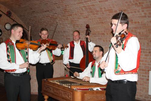 a group of men standing around a table withviolins at Penzion U Králíků in Kurdějov