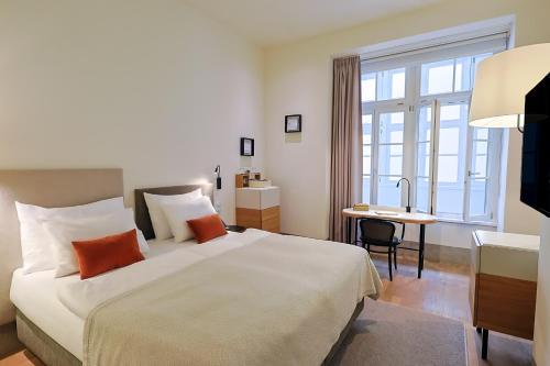 a hotel room with a large bed and a desk at Hotel BOOKQUET in Prague