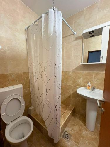 a bathroom with a toilet and a shower curtain at UnaMar 2 in Prčanj