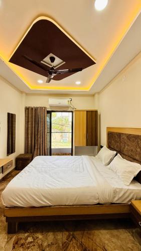 a bedroom with a large bed with a ceiling fan at Hotel Viraj in Indore