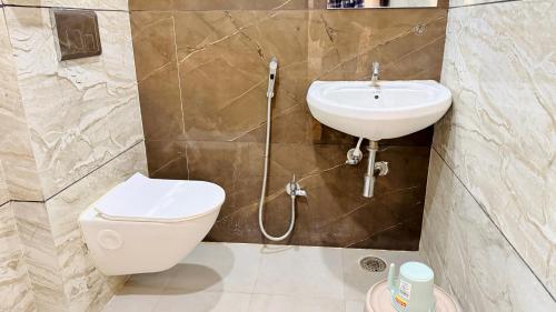 a bathroom with a toilet and a sink at Hotel Viraj in Indore