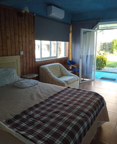 a bedroom with a bed and a couch and a chair at Casinhas do Ribeiro in Póvoa de Lanhoso