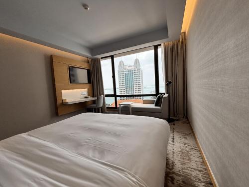 a hotel room with a bed and a view of a city at OZO George Town Penang in George Town
