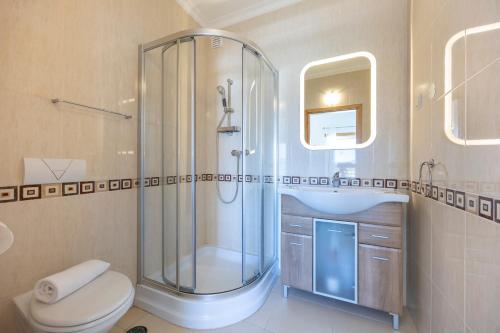 a bathroom with a shower and a toilet and a sink at Casa Iguana in Budens