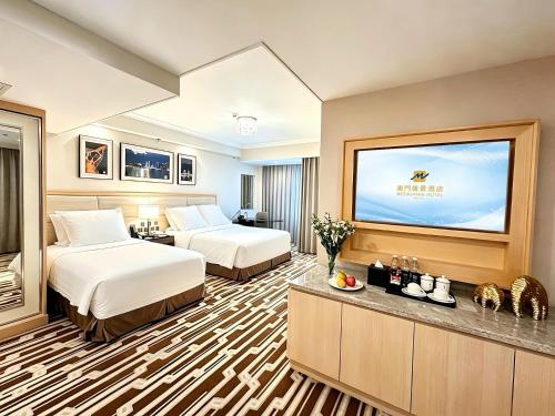a hotel room with two beds and a flat screen tv at 澳門維景酒店 in Macau