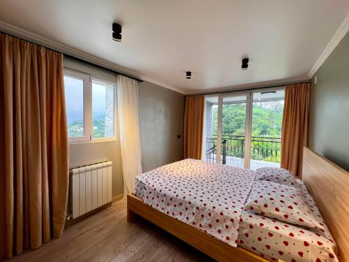 a bedroom with a bed and a large window at Botanic sea view in Batumi