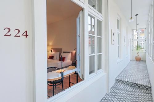 a hallway with a room with a bed and a window at Hotel BOOKQUET in Prague