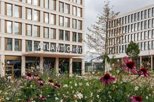 a building with a field of flowers in front of it at ATLANTIC Hotel Heidelberg in Heidelberg