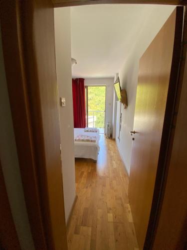 a hallway with a bedroom and a bed in a room at Eva in Pržno