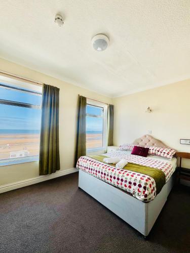 a bedroom with a bed and a large window at Cherish Lewis Sea View Hotel in Blackpool