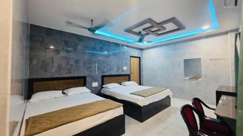 a bedroom with two beds and a blue light at Global Stay Mantralayam in Mādhavaram