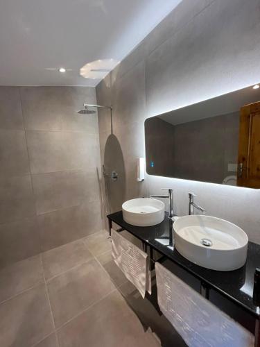 a bathroom with two sinks and a mirror at Gurra resort in Klos