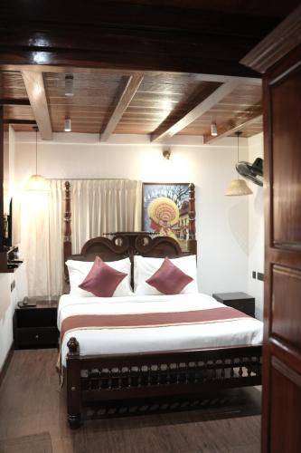 a bedroom with a large bed with red pillows at Suryamangalam Heritage in Cheruppulasseri
