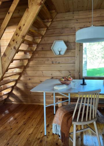 a room with a table and chairs in a cabin at Private Riverside Cabin, Utajärvi in Korhola