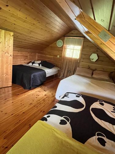 a bedroom with two beds in a log cabin at Private Riverside Cabin, Utajärvi in Korhola