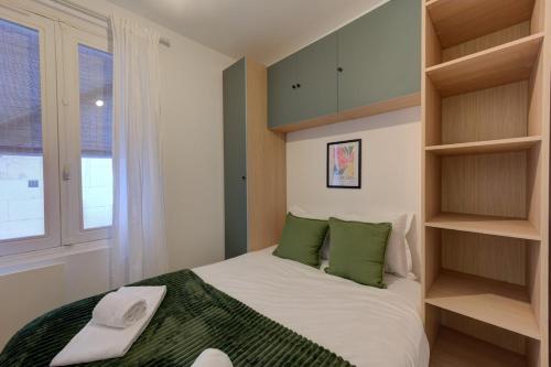 a bedroom with a bed with green pillows and shelves at Viktor 3 - Hyper Centre - Place Jean Jaurès in Tours