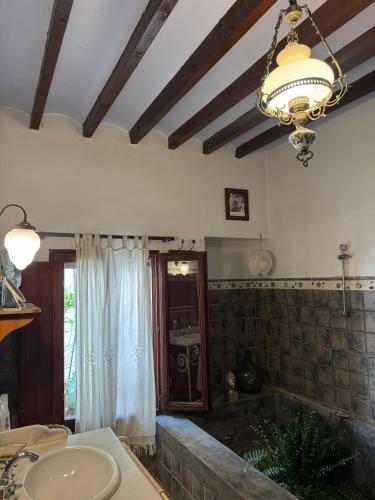 a bathroom with a tub and a sink and a chandelier at Casa Ana in Monóvar